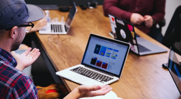 people in a meeting with laptops