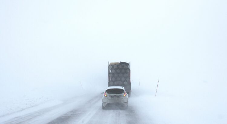 a car driving behind a lorry in snowy weather