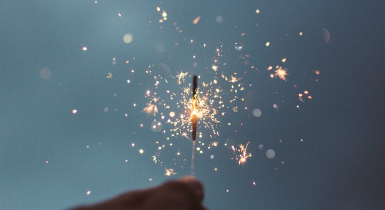 holding a sparkler against a dark sky